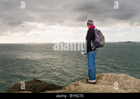 Donna in piedi sulla scogliera in Pembrokeshire Foto Stock