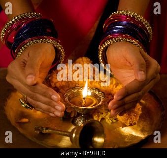 Le mani a coppa attorno a Diya Foto Stock