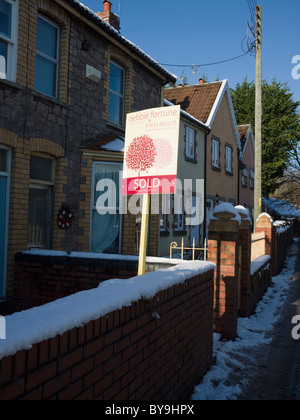 Un segno venduto fuori di un cottage villaggio in inverno. Wrington, Inghilterra. Foto Stock