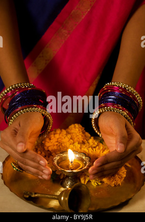 Le mani a coppa attorno a Diya Foto Stock