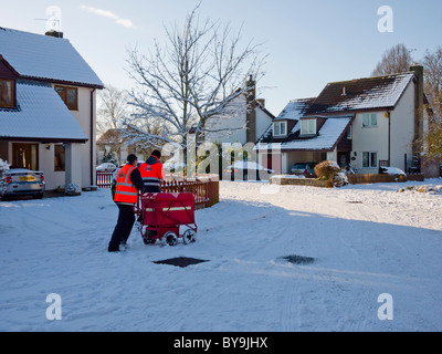 Due postini per strada che consegnano la posta alle case. Wrington, North Somerset, Inghilterra. Foto Stock