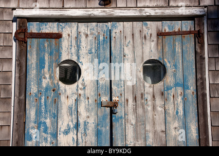 Weathered porte di un vecchio rustico, cedro casa incastrata sul Cape Cod, Massachusetts. Foto Stock