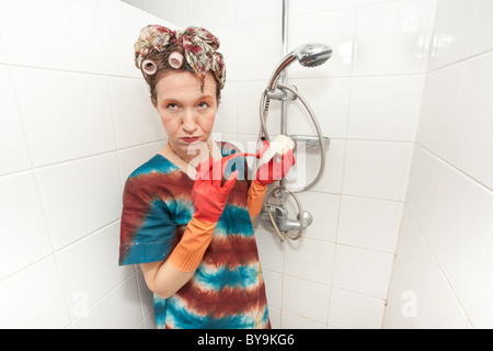 Funny donna annoiato per lavare il bagno doccia Foto Stock