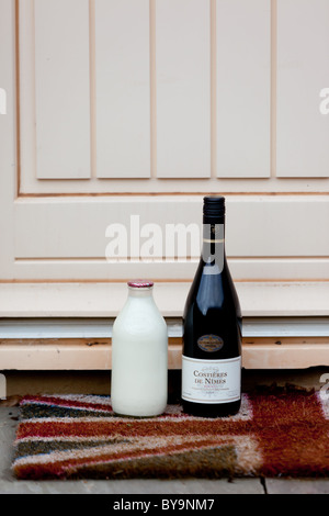Una bottiglia di latte ed un bottiglia di vino su una porta con una  bandiera europea zerbino Foto stock - Alamy