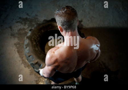 Un uomo forte tenta un sollevamento pneumatico. Foto Stock