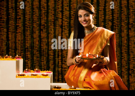 Ritratto di una donna che tiene un vassoio di diyas Foto Stock