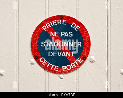 Il francese "Priere de ne pas Stationner / Devant Cette Porte' No parcheggio / nessuna attesa segnale di avvertimento - Francia. Foto Stock