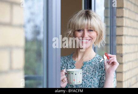 Donna che mantiene i tasti per il suo nuovo appartamento Foto Stock