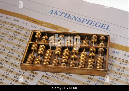 Chinese abacus giacente su un tedesco business quotidiano, immagine simbolica per influenza cinese sui mercati borsistici Foto Stock