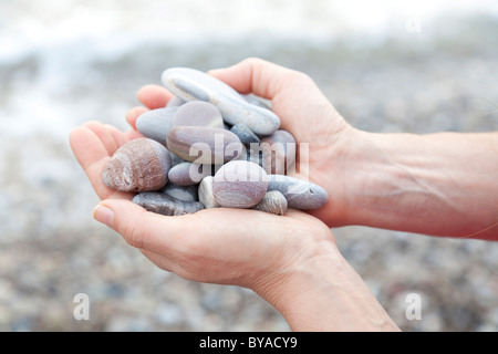 Mano che tiene la ghiaia Foto Stock