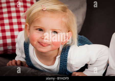 Le ragazze, 1,5 anni, con un commento irriverente il suo incollaggio con la lingua fuori Foto Stock