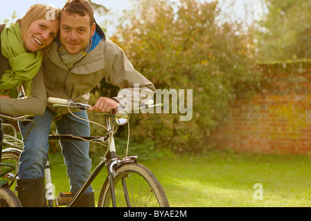 Giovane su vecchie biciclette, abbracciando. Caduta Foto Stock