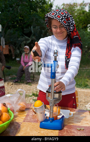 Donna vendita di fresca spremuta di arancia e il succo di melograno in Aspendos, Riviera Turca, Turchia, Asia Occidentale Foto Stock