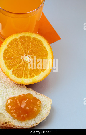 Arancione, succo di frutta e pane tostato con marmellata di arance concetto colazione Foto Stock