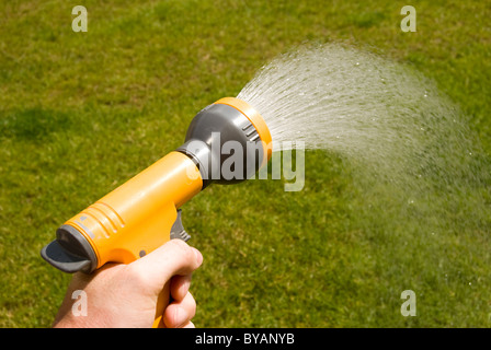Mano che tiene un Hozelock pistola ad acqua Foto Stock