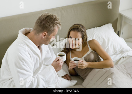 Coppia giovane di bere il caffè a letto Foto Stock