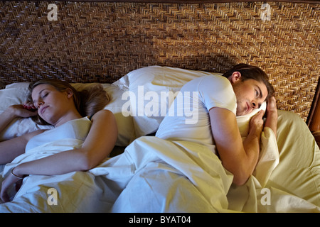 Caucasian coppia eterosessuale in letto, l'uomo che soffrono di insonnia. Sagoma orizzontale, ad alto angolo di visione Foto Stock