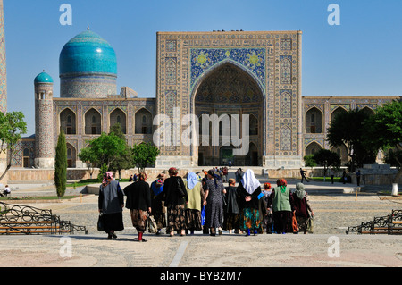 Donne uzbeke, Kori Tilya Madrasah, Registan Square a Samarcanda, Sito Patrimonio Mondiale dell'Unesco, Silk Road, Uzbekistan in Asia centrale Foto Stock