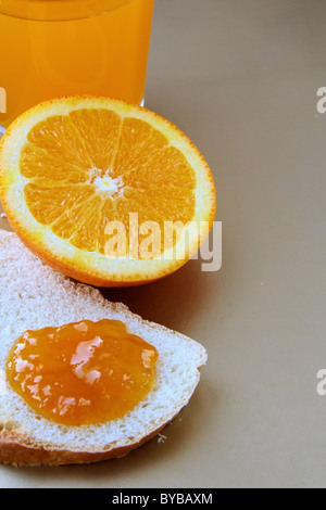 Arancione, succo di frutta e pane tostato con marmellata di arance concetto colazione Foto Stock