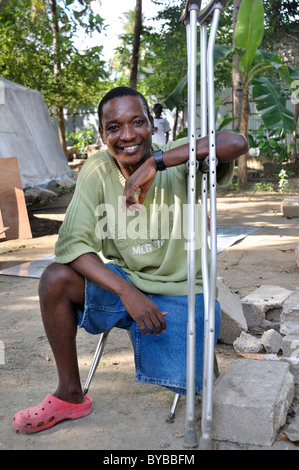 Terremoto vittima con amputata gamba appoggiata sulle sue stampelle, Port-au-Prince, Haiti, dei Caraibi e America centrale Foto Stock