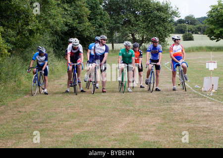 I ciclisti linea fino all'inizio di una pista in erba gara nelle zone rurali di Suffolk. Foto Stock