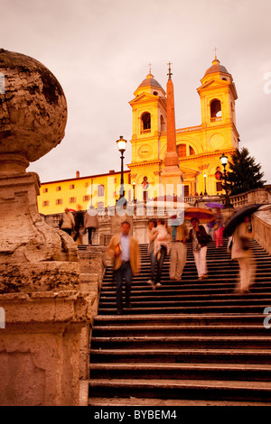 Sera la pioggia alla Scalinata di piazza di Spagna ha tutti raggiungendo per ombrelli sotto la chiesa di Trinità dei Monti, Roma Italia Foto Stock