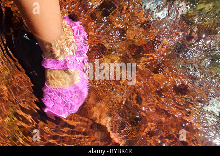 Ragazza piedi acqua scarpa rosa nel flusso del Fiume Rosso inferiore rolling stones Foto Stock