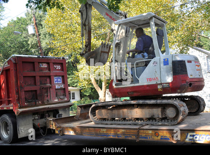 Lavoratore caricamento di un caricatore a estremità anteriore su un camion in Greenbelt, Md Foto Stock