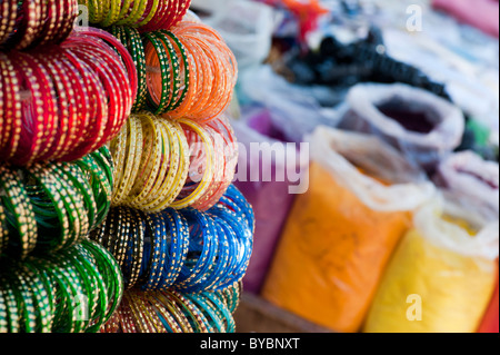 Vetro indiano schiave su un mercato in stallo nella parte anteriore dei sacchetti di polvere colorata. Andhra Pradesh, India Foto Stock