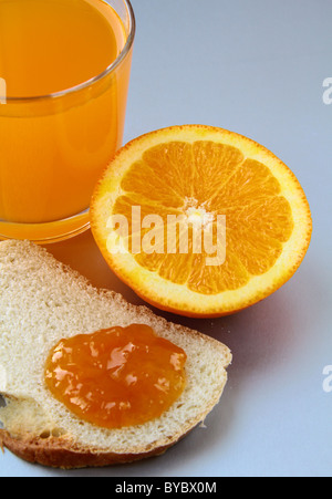 Arancione, succo di frutta e pane tostato con marmellata di arance concetto colazione Foto Stock