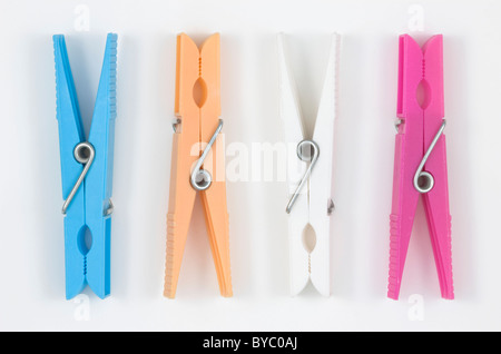 Quattro in plastica colorata clothespins; sul bianco. Foto Stock