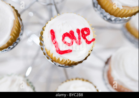 Tortine nel supporto con l'amore scritto sulla parte superiore Foto Stock