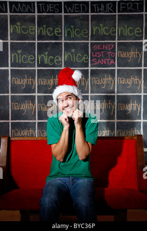 Elf uomo di fronte naughty e bel Natale calendario. Foto Stock
