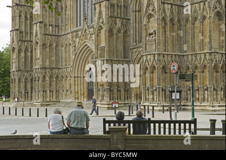 Quattro persone sedute e la visualizzazione della parte esterna di York Minster, North Yorkshire. Foto Stock