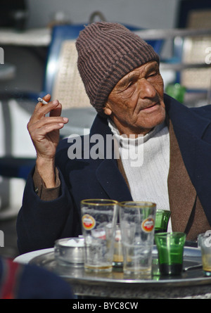 Il vecchio uomo di fumare sigarette in cafe, Sousse, Tunisia Foto Stock