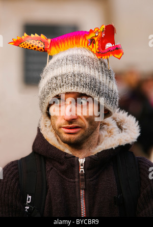 Giovane uomo che posano con drago di carta sulla testa. Capodanno cinese, Trafalgar Square, Londra, Regno Unito, Europa Foto Stock