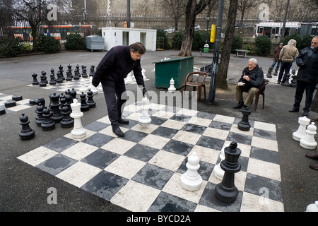 Le persone che giocano una partita di grandi / grande / giant / scacchi grandi in un parco pubblico a Ginevra / Geneve, Svizzera. Foto Stock