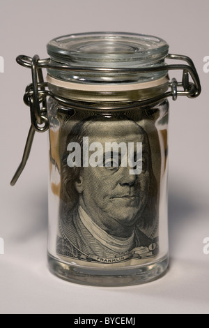 Mason Jar con un $100 bill all'interno mostra Benjamin Franklin del viso. Foto Stock