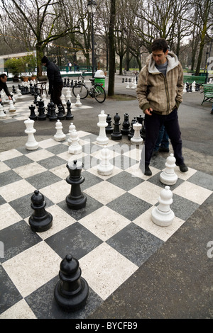 Player pesa le tattiche di gioco di riproduzione di grandi / grande / giant / scacchi grandi in un parco pubblico a Ginevra / Geneve, Svizzera. Foto Stock