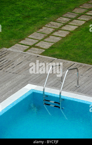 Vista aerea di una piscina esterna con ponte di legno e prato Foto Stock