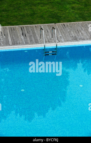 Vista aerea di una piscina esterna con ponte di legno e prato Foto Stock