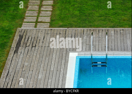 Vista aerea di una piscina esterna con ponte di legno e prato Foto Stock