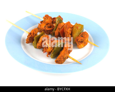 Appena cucinata o indiano stile Asiatico Pollo Tikka spiedini su spiedini contro uno sfondo bianco con nessun popolo e un tracciato di ritaglio Foto Stock