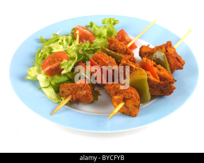 Appena cucinata o indiano stile Asiatico Pollo Tikka spiedini su spiedini contro uno sfondo bianco con nessun popolo e un tracciato di ritaglio Foto Stock