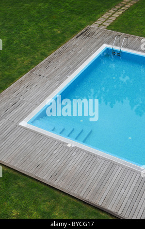 Vista aerea di una piscina esterna con ponte di legno e prato Foto Stock