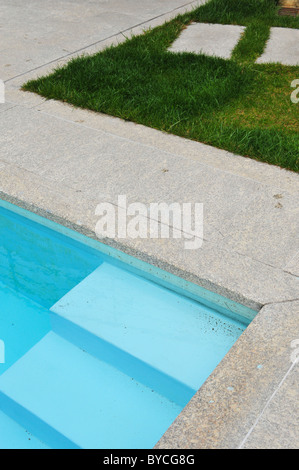 Dettaglio della piscina esterna entrata passi e prato con percorso di pietra Foto Stock