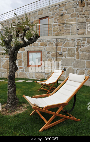 Ponte di Legno sedie con cuscini bianchi sul prato fuori del Casas da Lapa hotel, Lapa dos Dinheiros, Portogallo Foto Stock