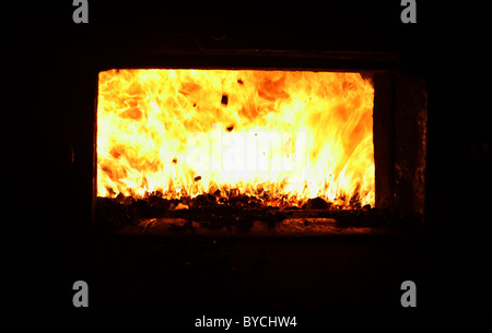 Intenso calore e fiamme nel fuoco della grata di una caldaia Foto Stock