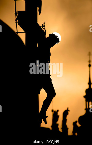 Praga - croce da H. Hilger 1629 sul Ponte Carlo da sunrise - silhouette Foto Stock