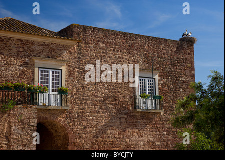 Il Portogallo, Algarve, torre medievale nelle mura della città, con una cicogna's Nest sulla parte superiore Foto Stock